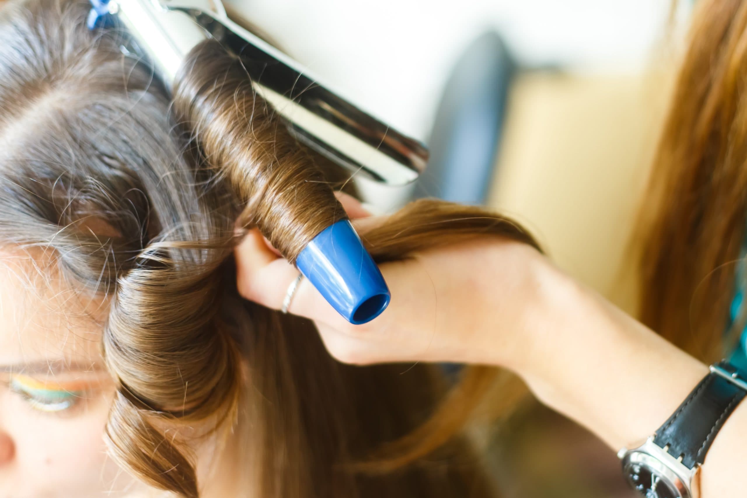 femme utilisant un fer à onduler